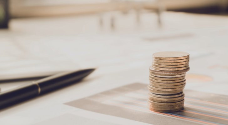 Stablet mønter og kuglepen ovenpå en aftale