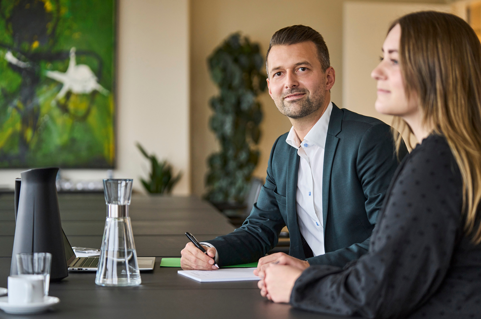 Lars Østerstrand og kvinde sidder ved bord 