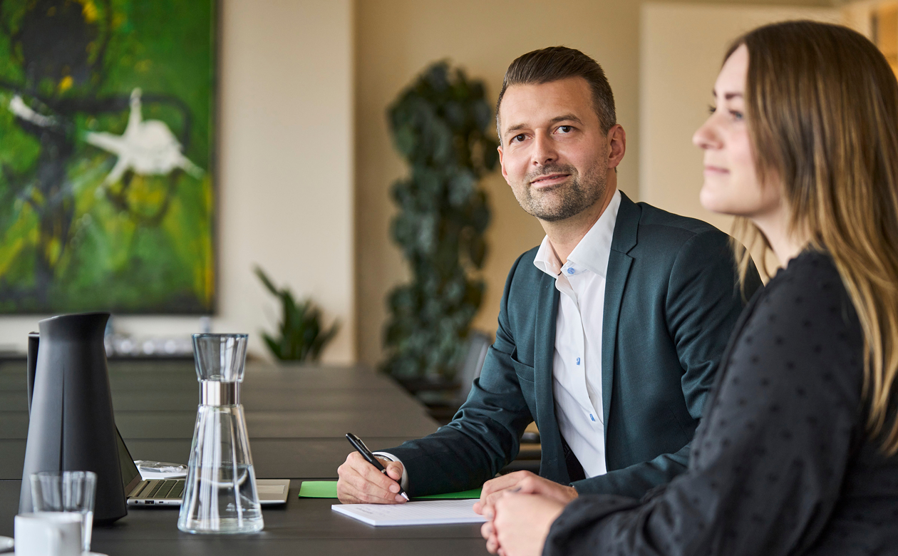 Lars Østerstrand og kvinde sidder ved bord 