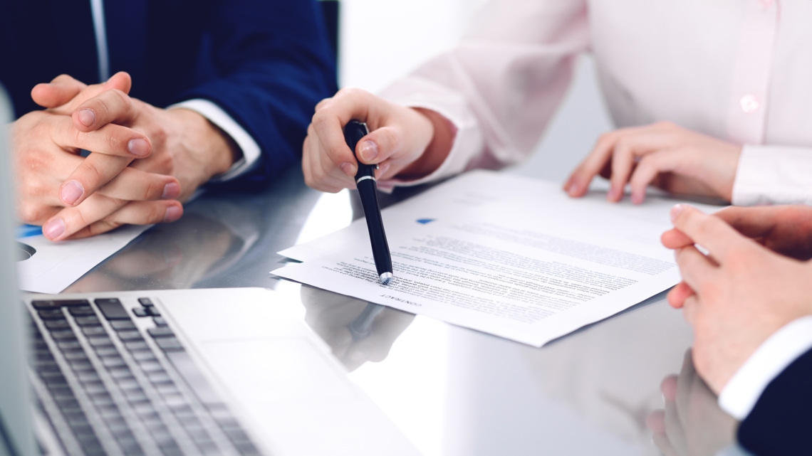 Tre personer i møde omkring kontrakt