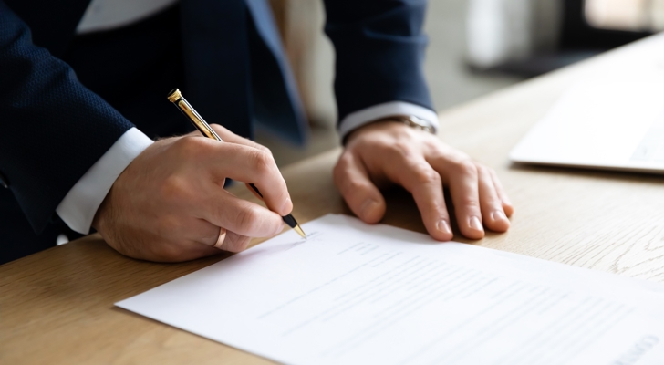 Mand underskriver dokument