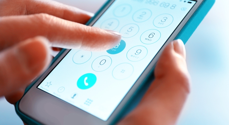 hænder der indtaster telefonnummer på mobil